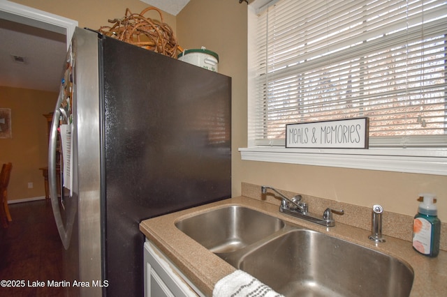 kitchen with visible vents, freestanding refrigerator, and a sink