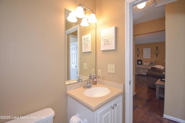 bathroom featuring toilet, wood finished floors, and vanity