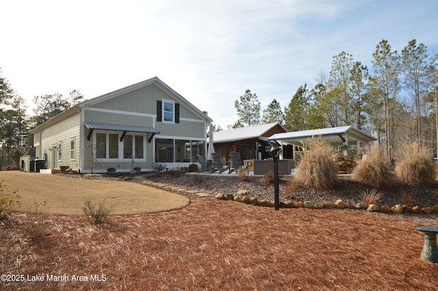 rear view of property featuring a sunroom