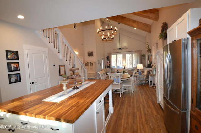 kitchen with butcher block countertops, stainless steel refrigerator, pendant lighting, hardwood / wood-style floors, and white cabinets