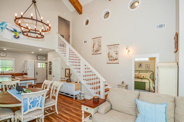 24 Hideaway Cir, Jacksons Gap, AL 36861 - living room with visible vents, wood finished floors, high vaulted ceiling, stairway, and a notable chandelier