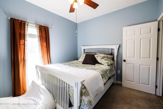 bedroom featuring dark carpet and ceiling fan