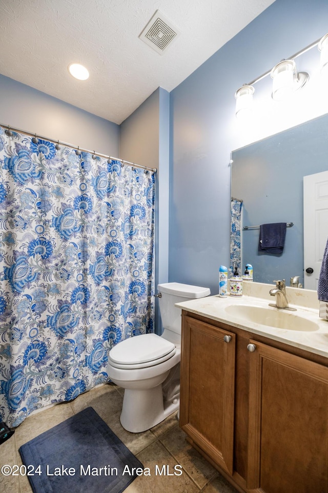 bathroom with vanity, tile patterned floors, a textured ceiling, and toilet