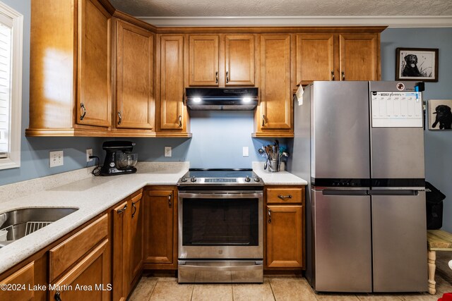 kitchen with light tile patterned flooring, stainless steel appliances, and a textured ceiling