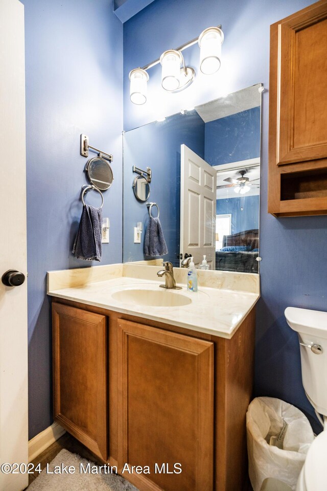 bathroom with vanity, toilet, and ceiling fan