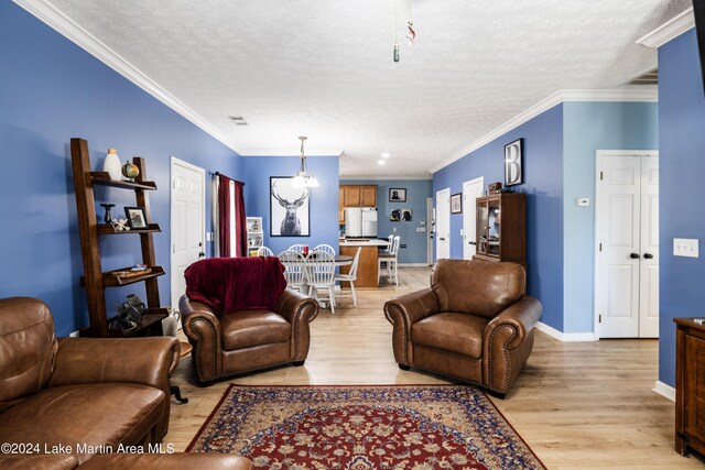 living room featuring a textured ceiling, light hardwood / wood-style floors, an inviting chandelier, and crown molding