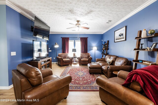 living room with ceiling fan, light hardwood / wood-style floors, a textured ceiling, and ornamental molding