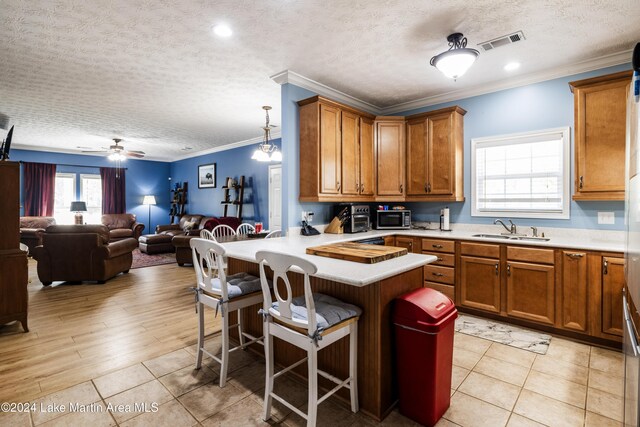 kitchen featuring a breakfast bar, light tile patterned flooring, decorative light fixtures, and ceiling fan with notable chandelier