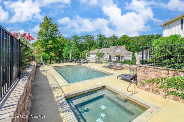 view of pool featuring an in ground hot tub and a patio