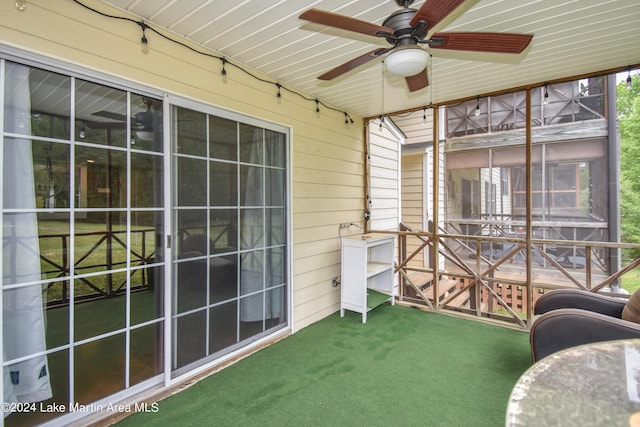 unfurnished sunroom with ceiling fan