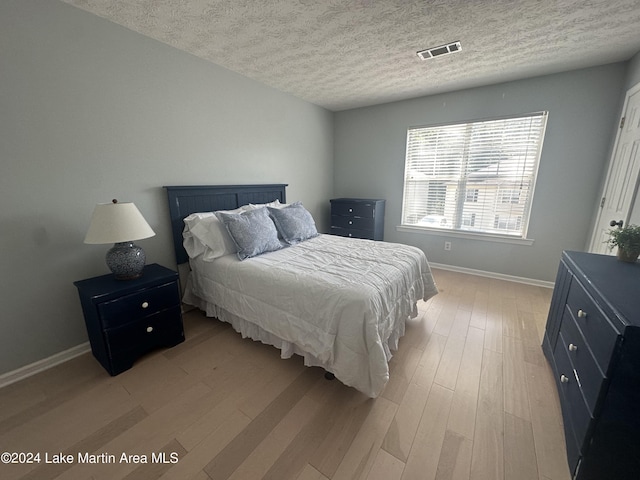 bedroom featuring a textured ceiling and light wood-type flooring