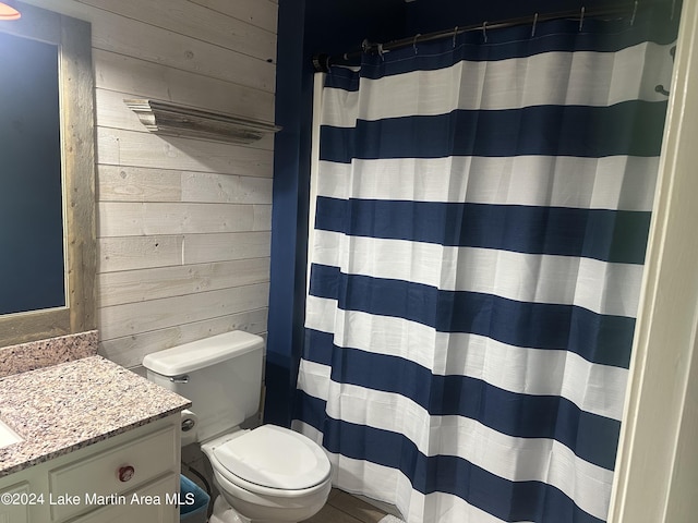 bathroom with curtained shower, toilet, vanity, and wood walls