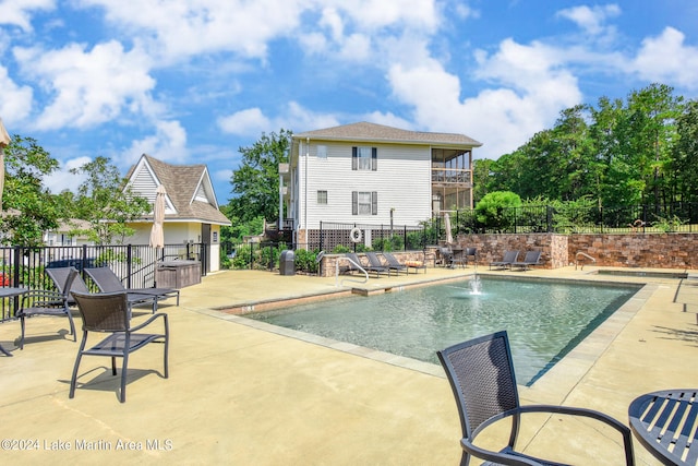 view of swimming pool with pool water feature and a patio