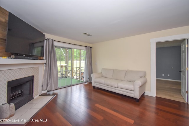 unfurnished living room featuring a tiled fireplace and wood-type flooring