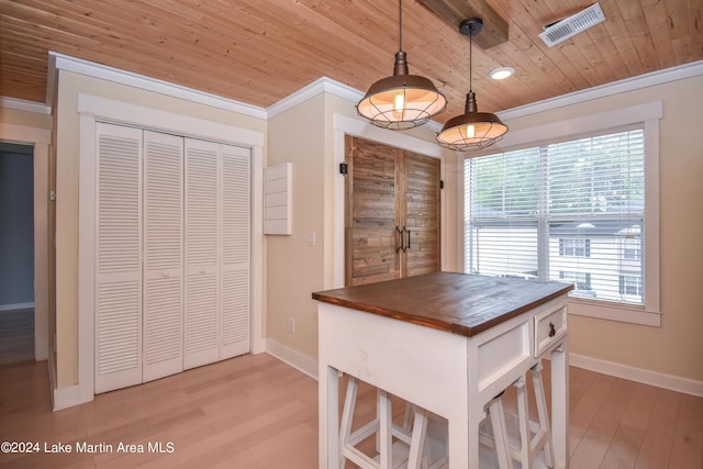 kitchen featuring hanging light fixtures, butcher block countertops, a breakfast bar area, and wood ceiling