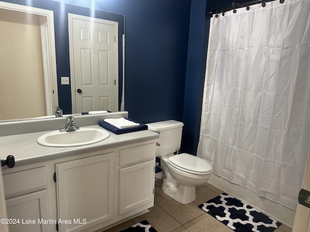 full bathroom featuring toilet, vanity, tile patterned flooring, and shower / bathtub combination with curtain