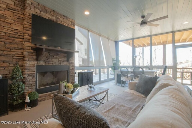 living room featuring wooden ceiling, a fireplace, floor to ceiling windows, and a ceiling fan