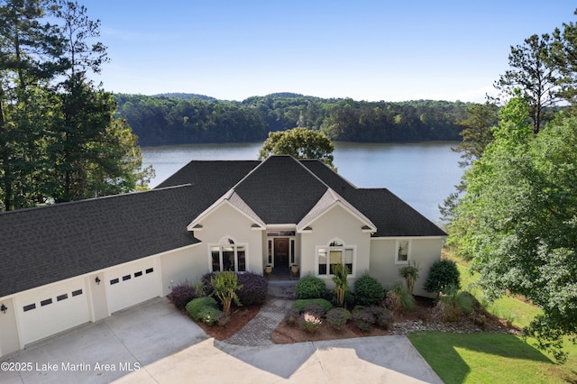 1689 River Oaks Dr, Jacksons Gap, AL 36861 - traditional-style home featuring a garage, a water view, roof with shingles, and concrete driveway