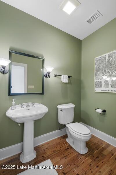1689 River Oaks Dr, Jacksons Gap, AL 36861 - half bathroom featuring wood finished floors, toilet, and baseboards