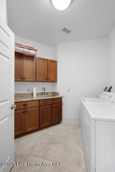1689 River Oaks Dr, Jacksons Gap, AL 36861 - clothes washing area featuring separate washer and dryer, cabinet space, and baseboards