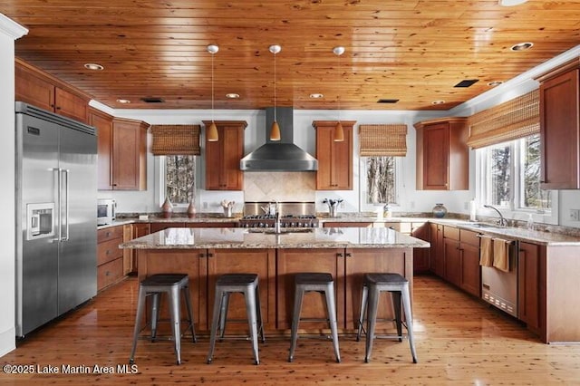 1689 River Oaks Dr, Jacksons Gap, AL 36861 - kitchen with stainless steel appliances, wall chimney range hood, plenty of natural light, a center island with sink, and wood ceiling