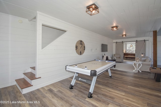 rec room featuring wood ceiling, hardwood / wood-style flooring, and a barn door