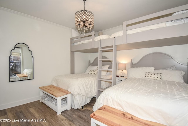 bedroom featuring an inviting chandelier, dark hardwood / wood-style floors, and ornamental molding