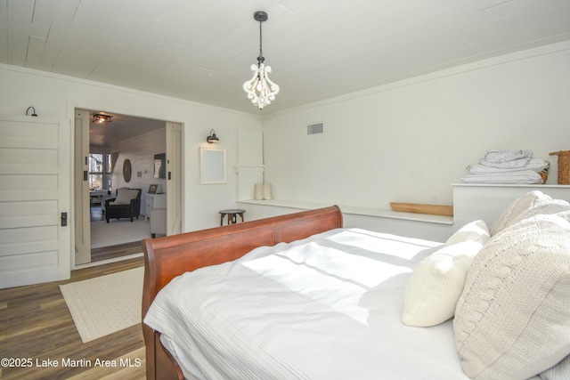 bedroom featuring ornamental molding, a chandelier, and dark hardwood / wood-style flooring