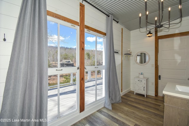 bathroom featuring a healthy amount of sunlight, hardwood / wood-style flooring, and wood walls