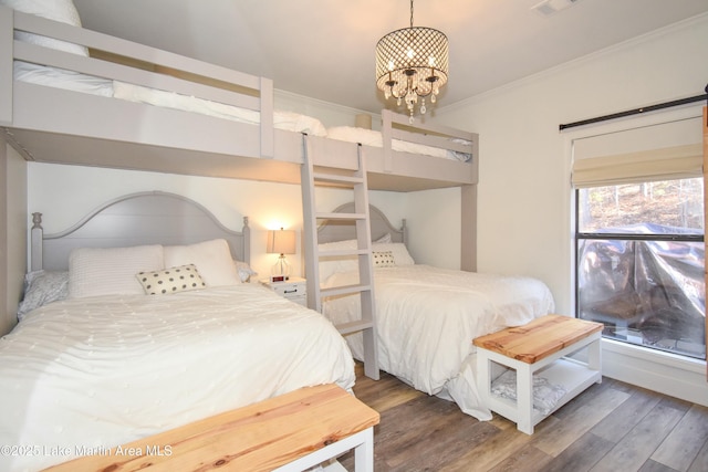 bedroom with crown molding, dark hardwood / wood-style floors, and an inviting chandelier