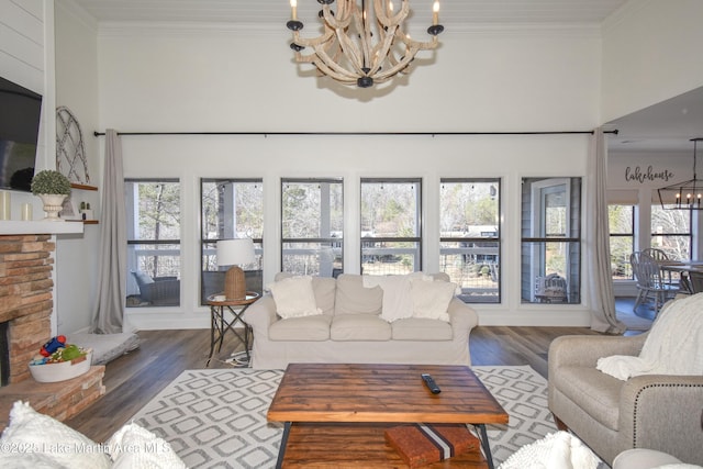 living room featuring a notable chandelier, ornamental molding, dark hardwood / wood-style floors, and a towering ceiling