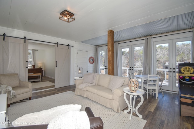 living room featuring french doors, dark hardwood / wood-style flooring, and a barn door