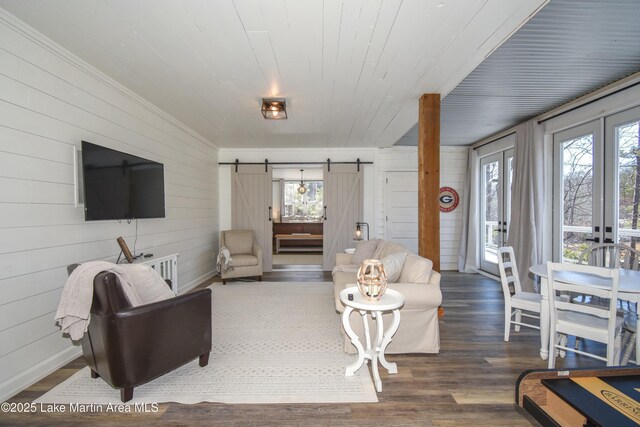 living room with wood ceiling, a barn door, and dark hardwood / wood-style floors