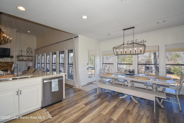 kitchen featuring hanging light fixtures, sink, dishwasher, white cabinets, and a chandelier