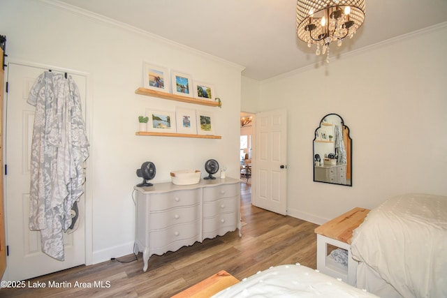 bedroom with light wood-type flooring, a chandelier, and ornamental molding