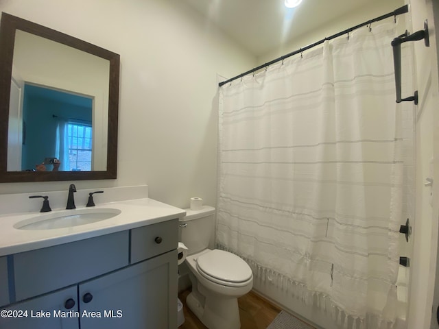 bathroom with hardwood / wood-style floors, vanity, toilet, and a shower with curtain