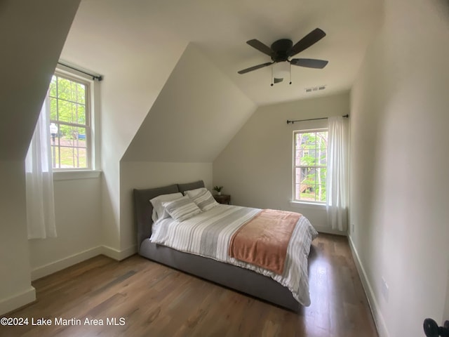 bedroom with hardwood / wood-style flooring, vaulted ceiling, multiple windows, and ceiling fan