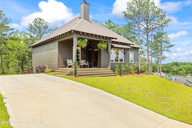 224 Village Trl, Dadeville, AL 36853 - bungalow-style house with a front yard, a shingled roof, and a chimney