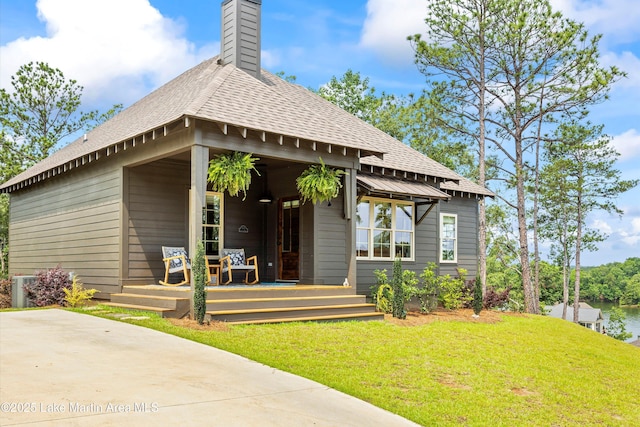 224 Village Trl, Dadeville, AL 36853 - view of front of home featuring a front yard, a chimney, roof with shingles, and covered porch