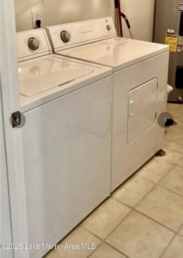 laundry room with electric water heater, light tile patterned floors, laundry area, and separate washer and dryer