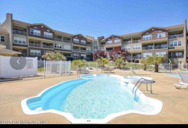 community pool with fence and a patio