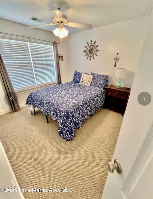 bedroom with baseboards, ceiling fan, visible vents, and carpet floors