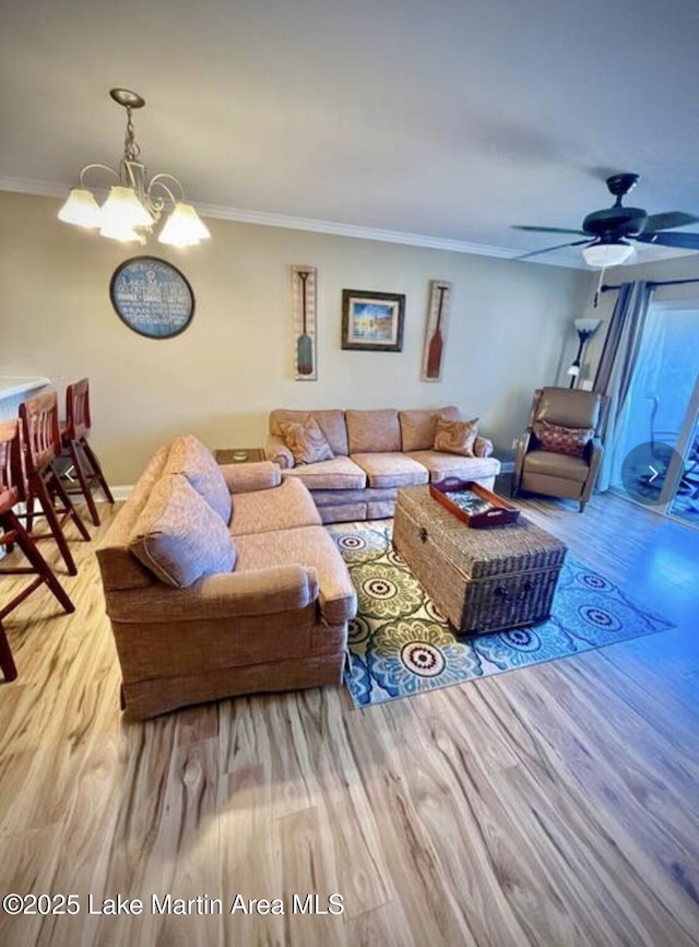 living area with light wood finished floors, crown molding, and ceiling fan with notable chandelier