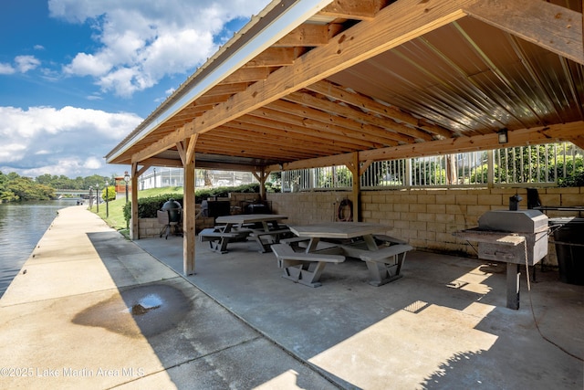view of patio with grilling area and a water view