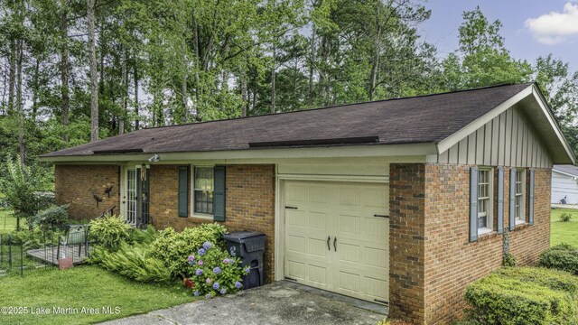 1751 Clubview Dr, Alexander City, AL 35010 - view of front of property with board and batten siding, an attached garage, brick siding, and roof with shingles