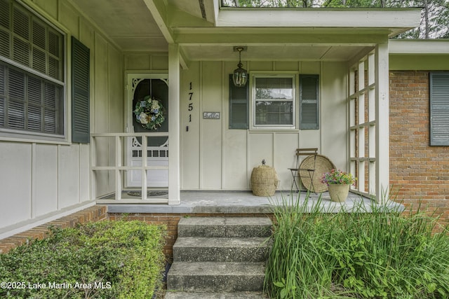 1751 Clubview Dr, Alexander City, AL 35010 - view of exterior entry featuring board and batten siding, a porch, and brick siding