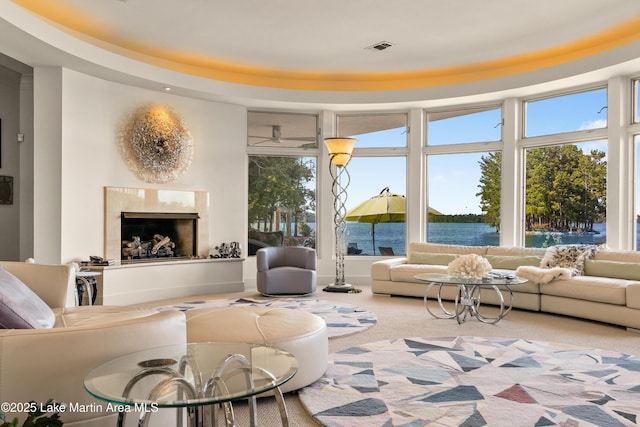 1020 Wake Robin, Eclectic, AL 36024 - carpeted living area featuring visible vents, a high end fireplace, and a water view