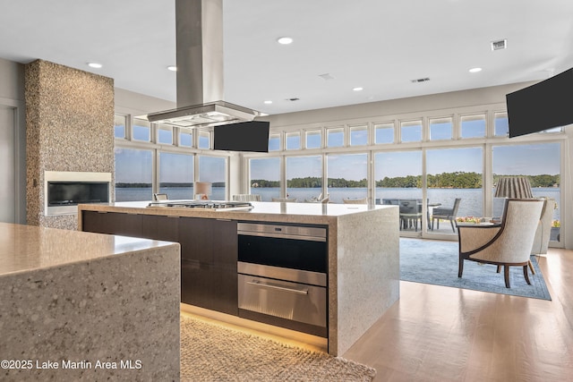 1020 Wake Robin, Eclectic, AL 36024 - kitchen with island range hood, appliances with stainless steel finishes, modern cabinets, recessed lighting, and light wood-style flooring