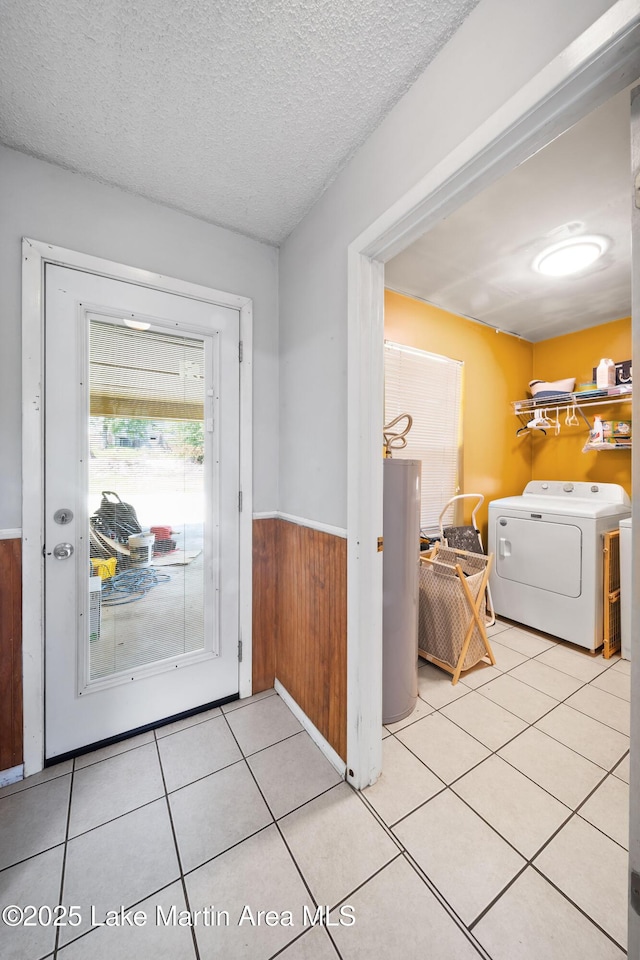 1258 Watson St, Alexander City, AL 35010 - laundry room featuring wainscoting, washing machine and clothes dryer, water heater, light tile patterned floors, and wood walls