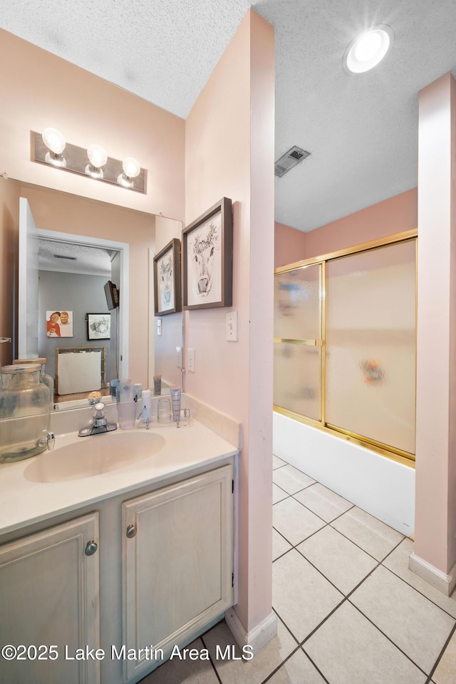 1258 Watson St, Alexander City, AL 35010 - bathroom with vanity, combined bath / shower with glass door, tile patterned flooring, and a textured ceiling
